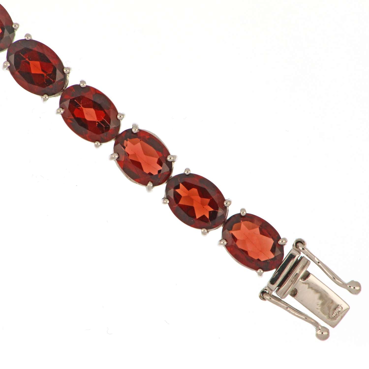 Side angle of white gold garnet bracelet highlighting the oval garnets and delicate claw settings