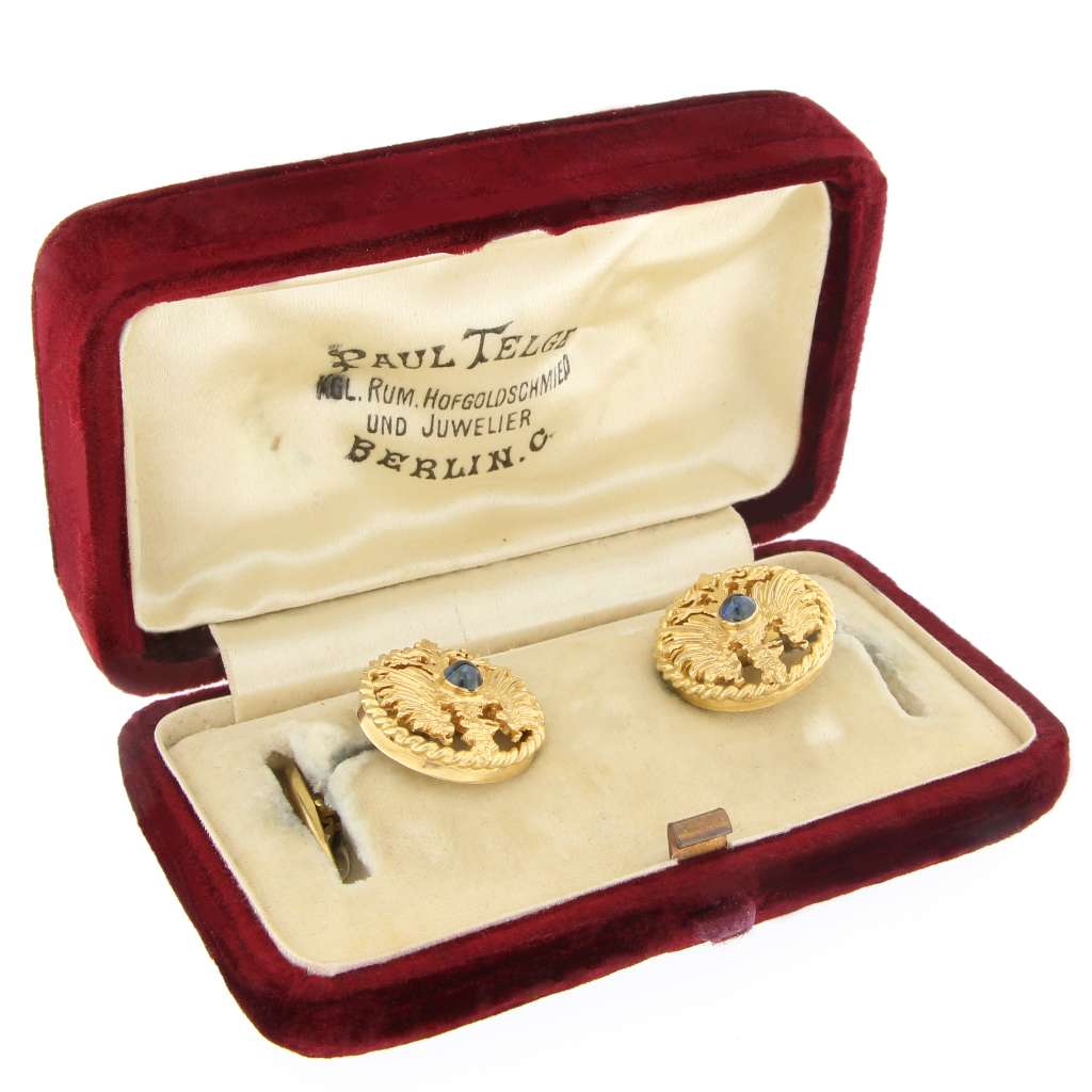 Close-up side view of yellow gold cufflink highlighting smooth cabochon blue sapphire stone and polished finish