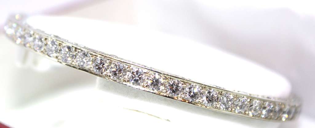 Side angle of 18kt white gold diamond bangle displaying diamond setting and overall weight impression