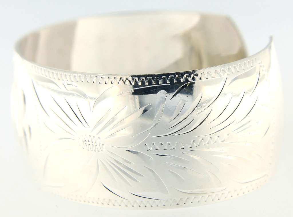 Side view of sterling silver bangle with open end showing curve and thickness