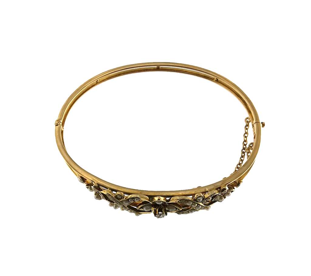 Close-up of old mine cut diamond and surrounding white seed pearls on 14kt yellow gold bangle