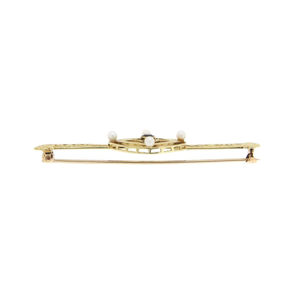 Close-up side angle of 14kt yellow gold amethyst and pearl brooch showing detailed craftsmanship