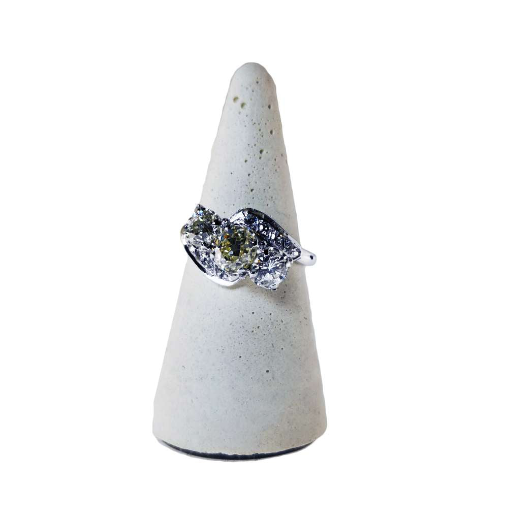 Close-up of 18kt white gold ring featuring old mine cut diamond center and two round side diamonds, vintage style