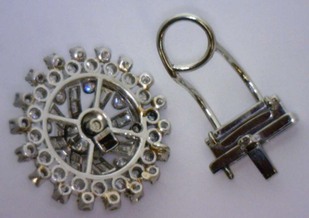 Close-up image focusing on the three large round center diamonds in the antique brooch