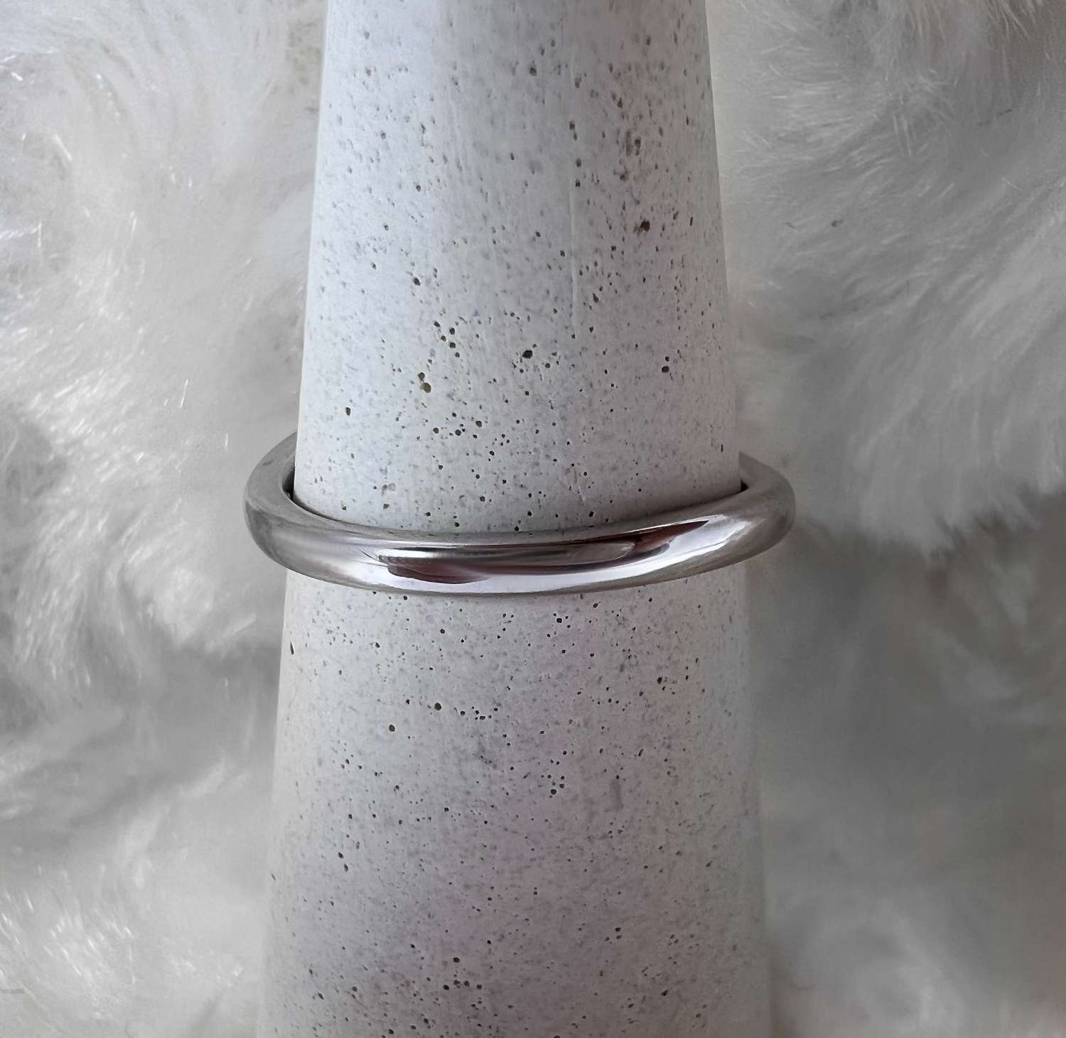 Side view of 10kt white gold diamond ring revealing profile of claw set round diamond and band weight