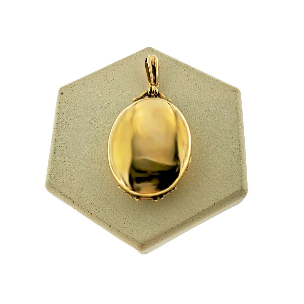 Side angle of 16kt yellow gold antique style locket pendant showing thickness and antique detailing