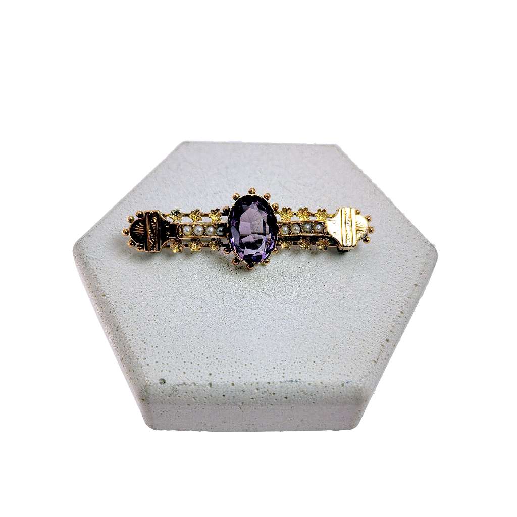 Antique 9kt yellow gold brooch featuring an oval purple amethyst and seed pearls, showing front close-up angle