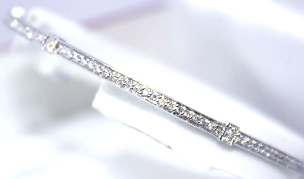 Side angle of luxurious 18kt white gold diamond bangle showcasing diamond setting and 14.84 gram weight
