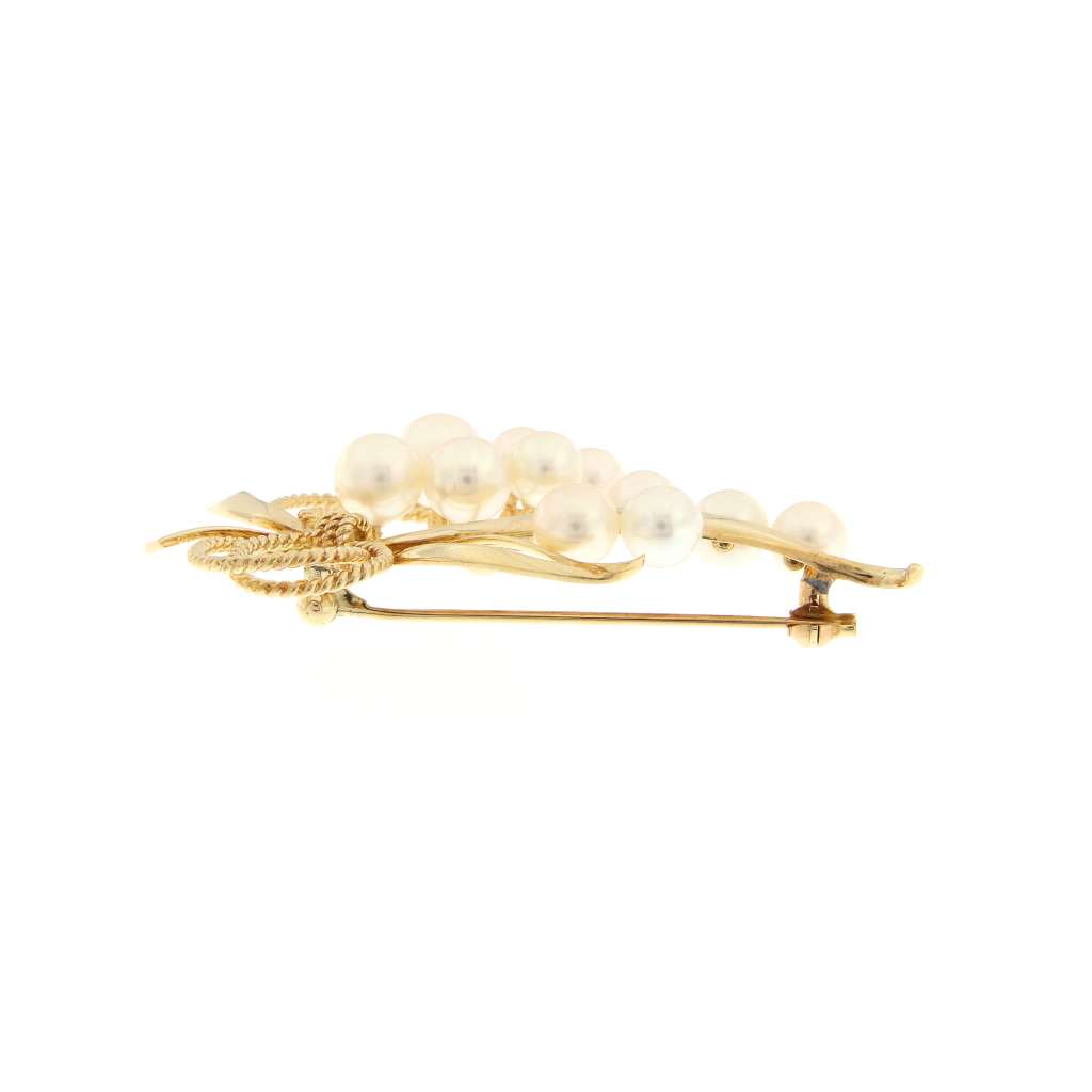 Close-up of 14kt yellow gold pearl brooch highlighting lustrous white cultured pearls and refined craftsmanship