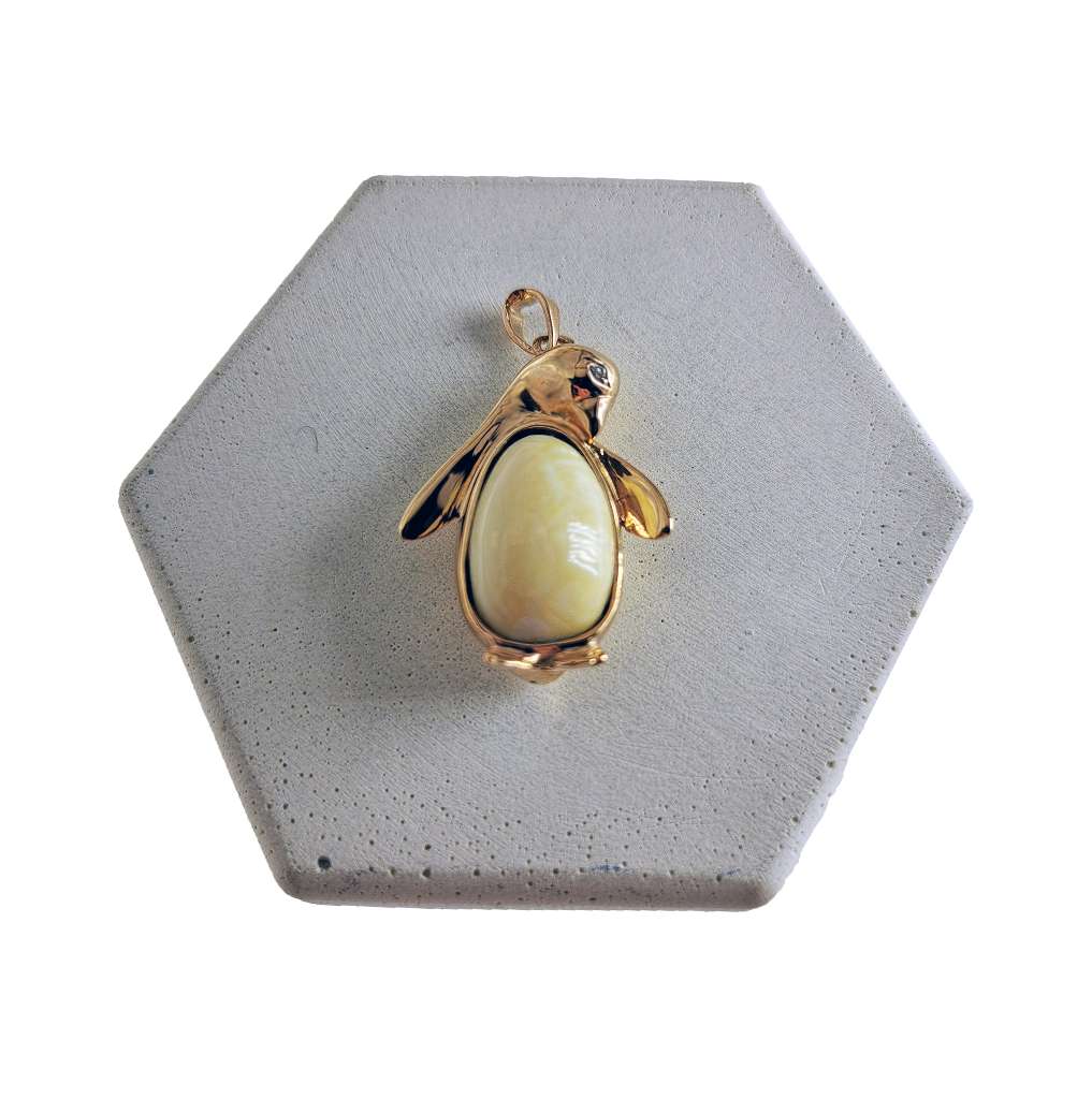 Close-up of 14kt yellow gold pendant featuring a penguin design with an oval elephant ivory centerpiece, displaying intricate metalwork with 8.86 grams total weight