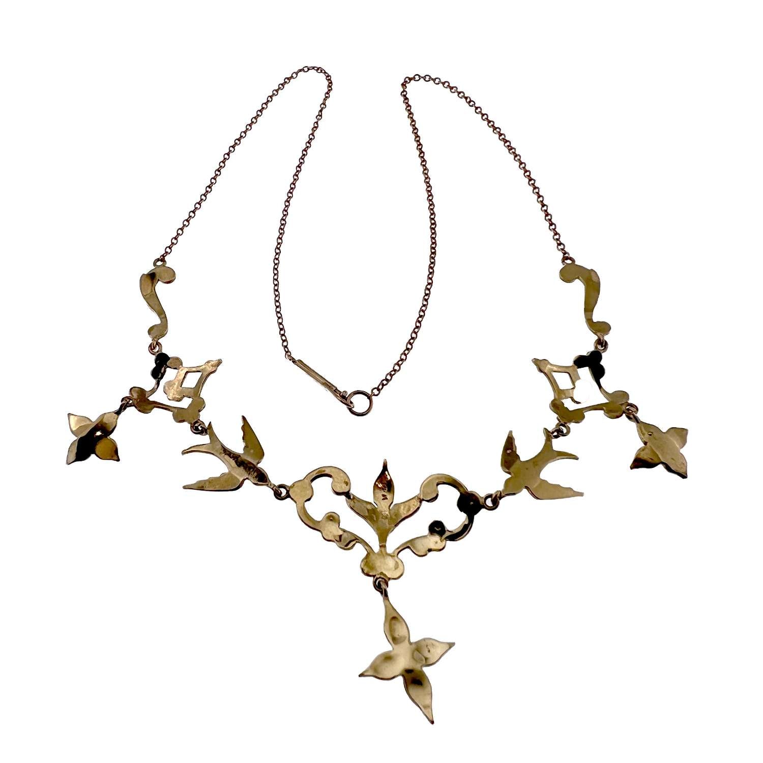 Detailed view of vintage 14kt yellow gold necklace featuring seed pearls arranged in flower and bird design