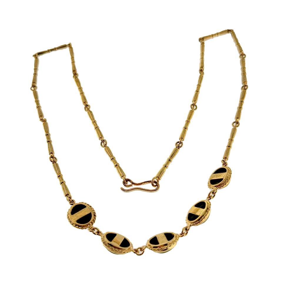 Full view of elegant 9kt yellow gold black onyx necklace highlighting atomic oval gemstones and lustrous gold chain