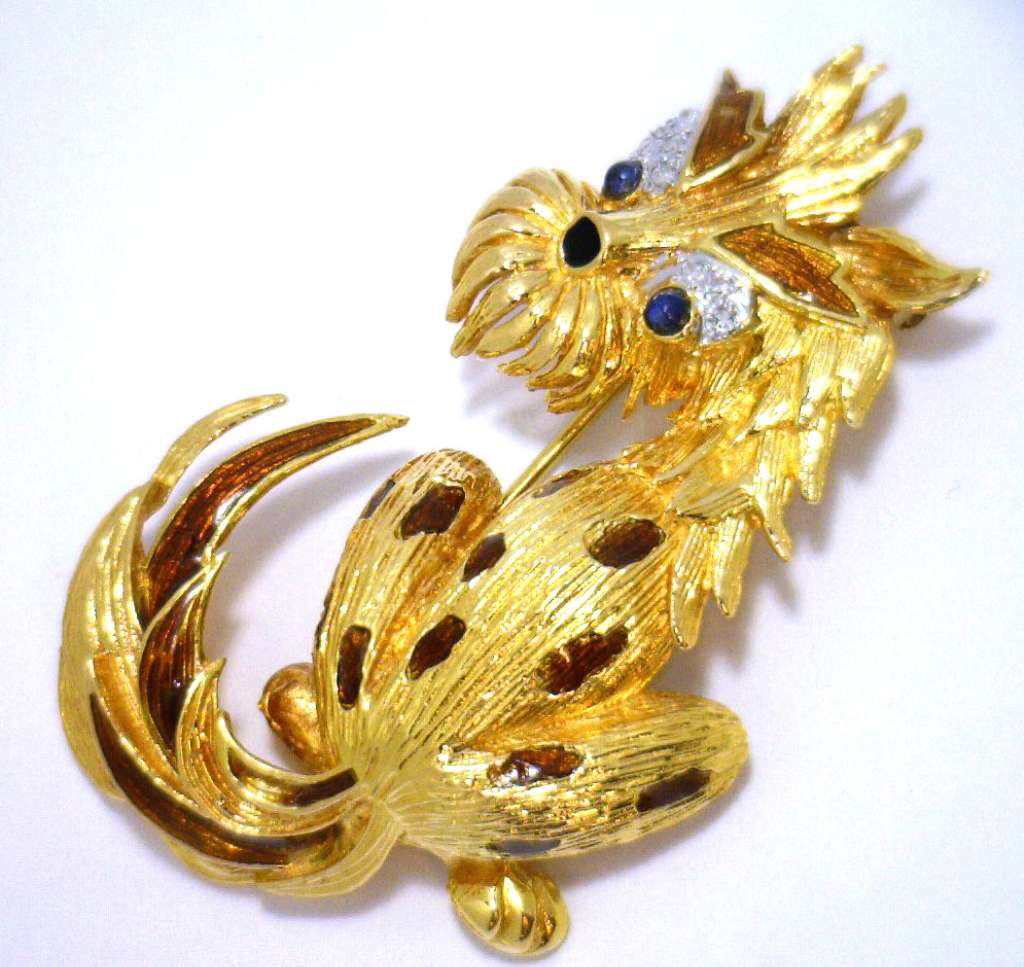 18kt yellow gold stylized dog brooch front view showcasing black and brown enamel body with blue sapphire eyes and diamond accents