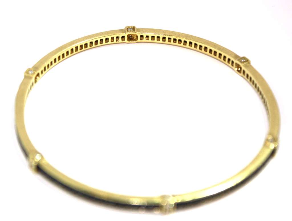 Side angle of 18kt yellow gold black diamond bangle displaying intricate diamond setting and metalwork
