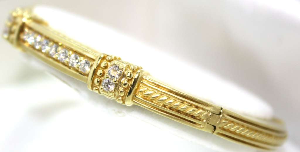 Detailed shot focusing on sparkling round diamonds set in 18kt yellow gold bangle weighing 39.31 grams