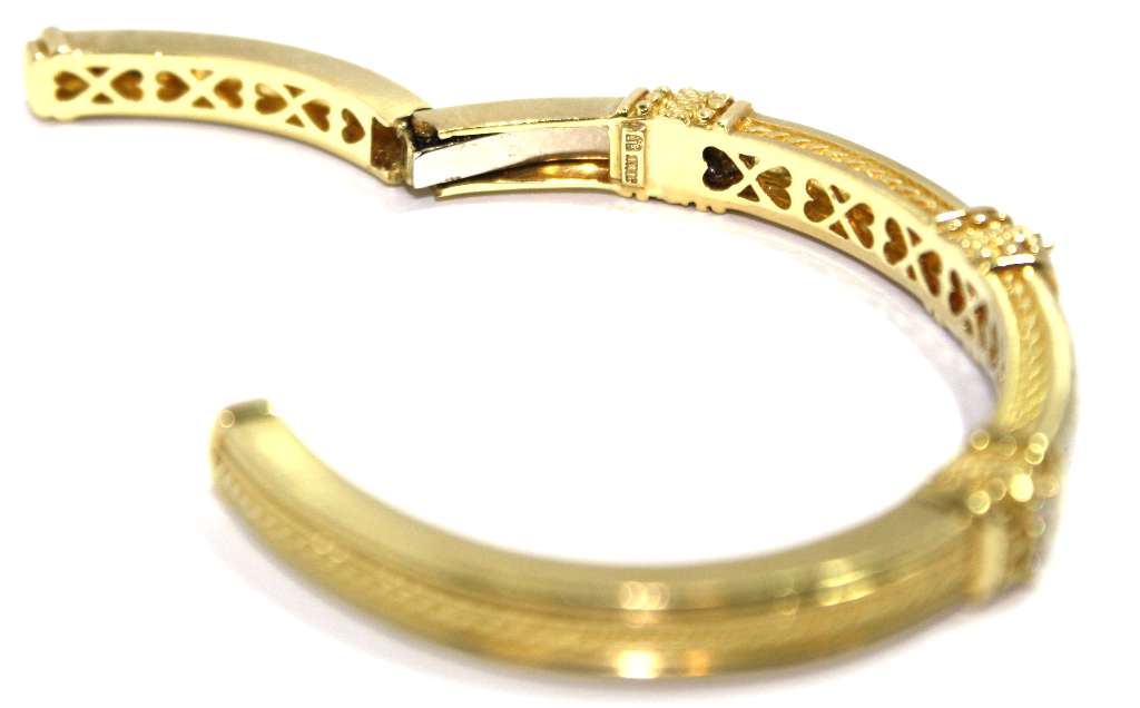 Elegant 18kt yellow gold diamond bangle displayed on wrist with bright round brilliant cut diamonds