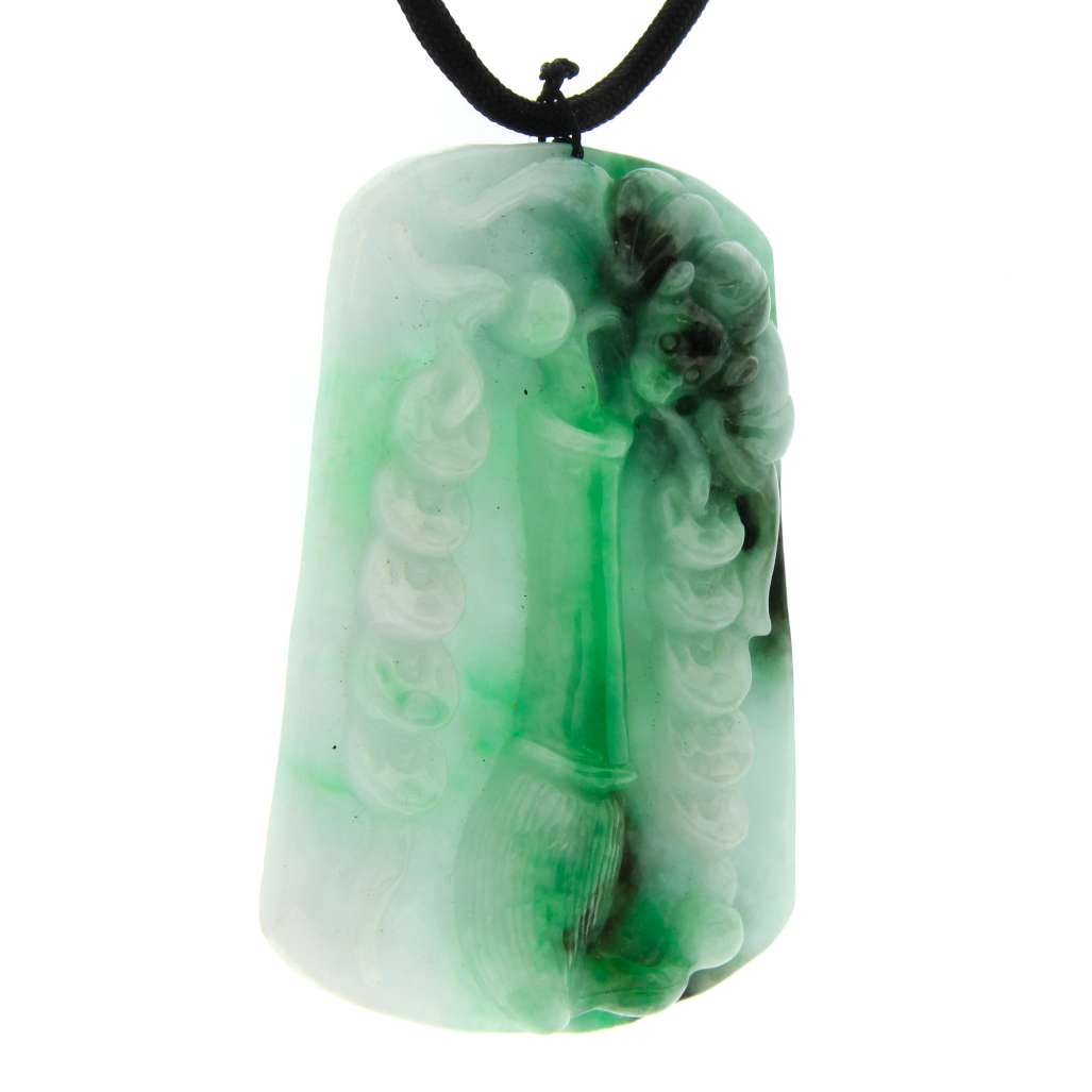 Close-up of Burmese jadeite jade pendant showing double-sided carving with bat motif in light and dark green tones