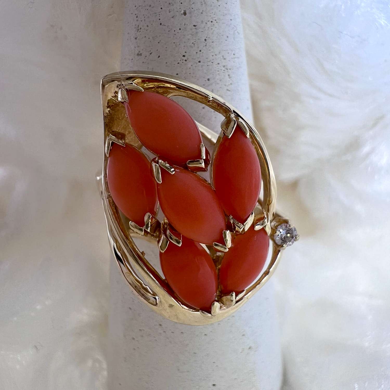 14kt yellow gold ring featuring six marquise-shaped pink coral stones and one full cut diamond viewed from top angle