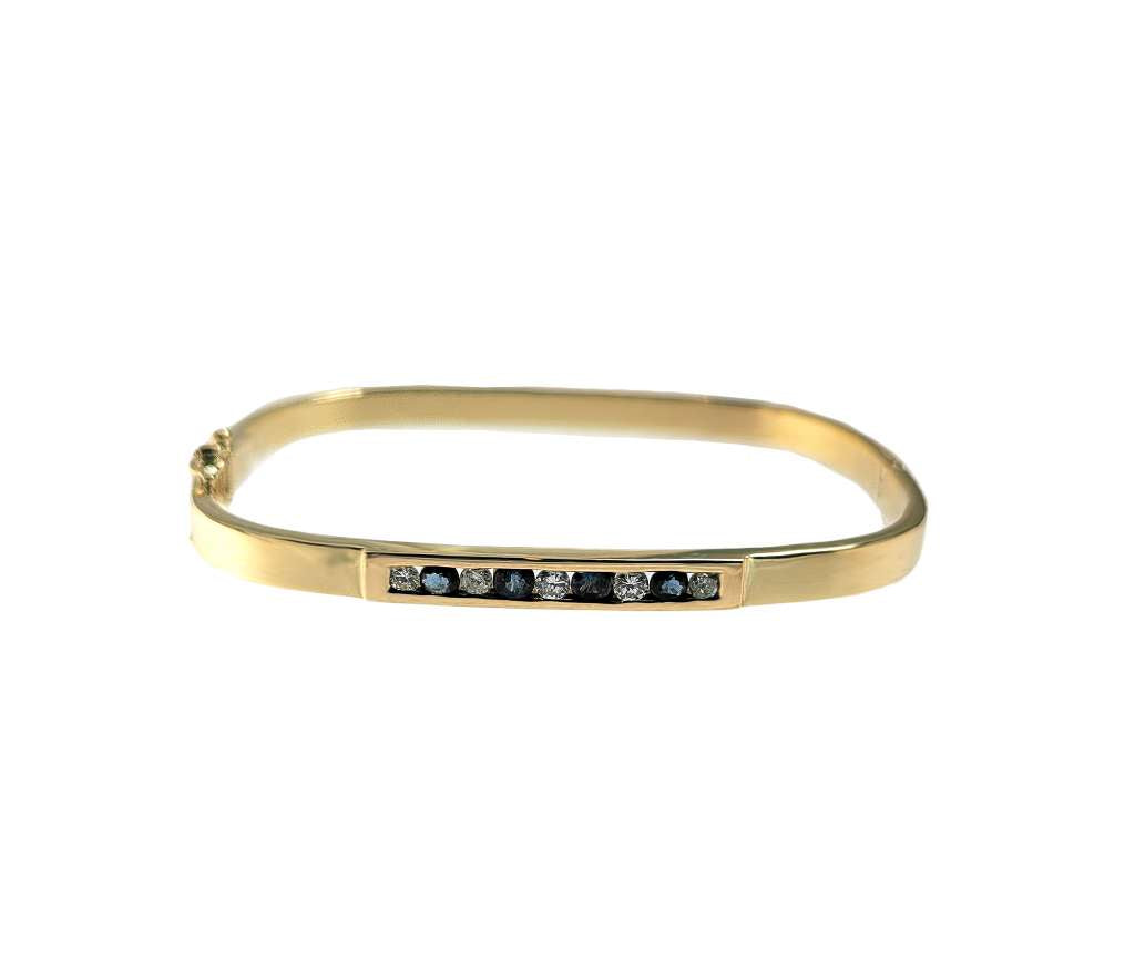 12kt yellow gold bangle featuring four round blue sapphires and five full cut diamonds in a channel setting, front angle view