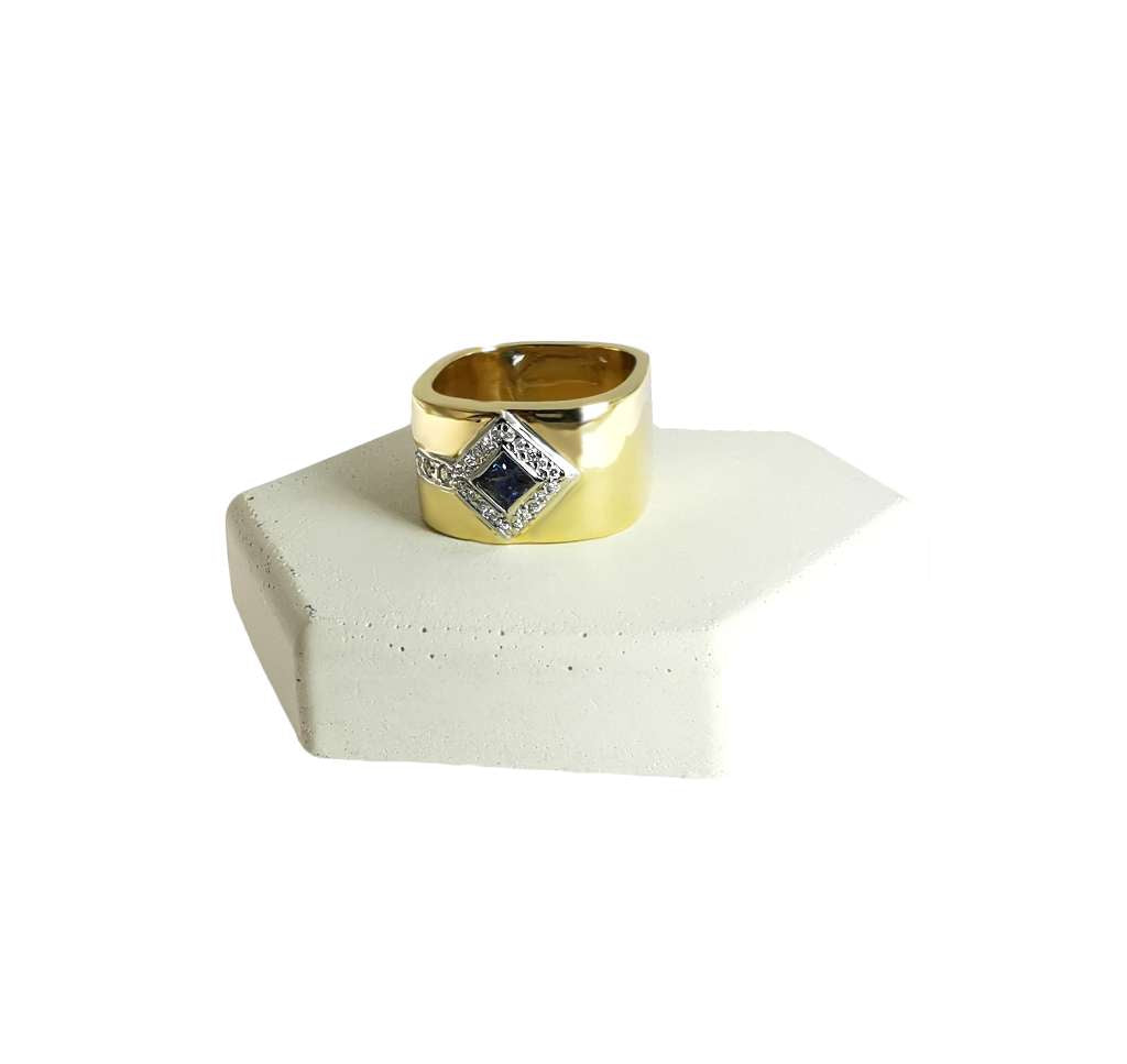 Close-up of 18kt yellow gold sapphire ring highlighting blue sapphire and diamond arrangement