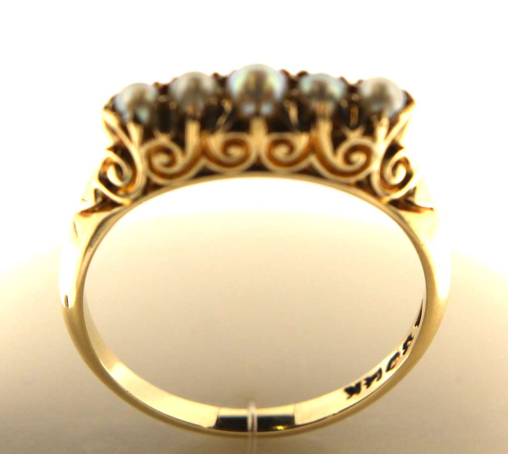 Side profile of 14kt yellow gold ring with five white pearls, display of craftsmanship and elegant design