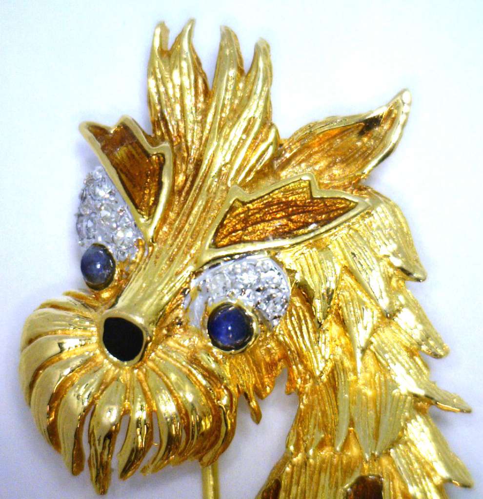Artistic angle of yellow gold dog brooch showing detailed enamel textures and gemstone settings