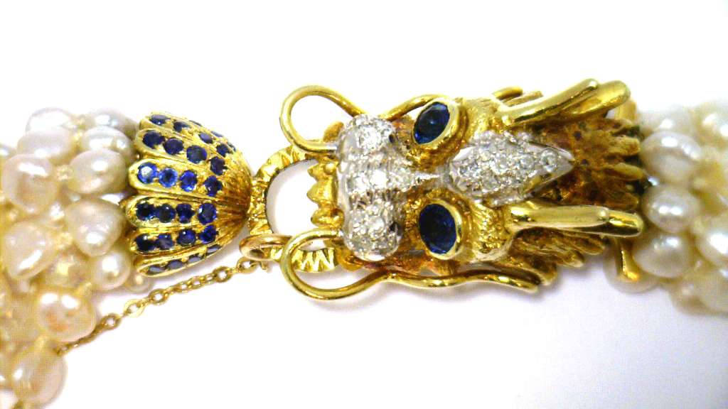 Overhead image displaying eight strands of freshwater pearls attached to yellow gold dragon clasp