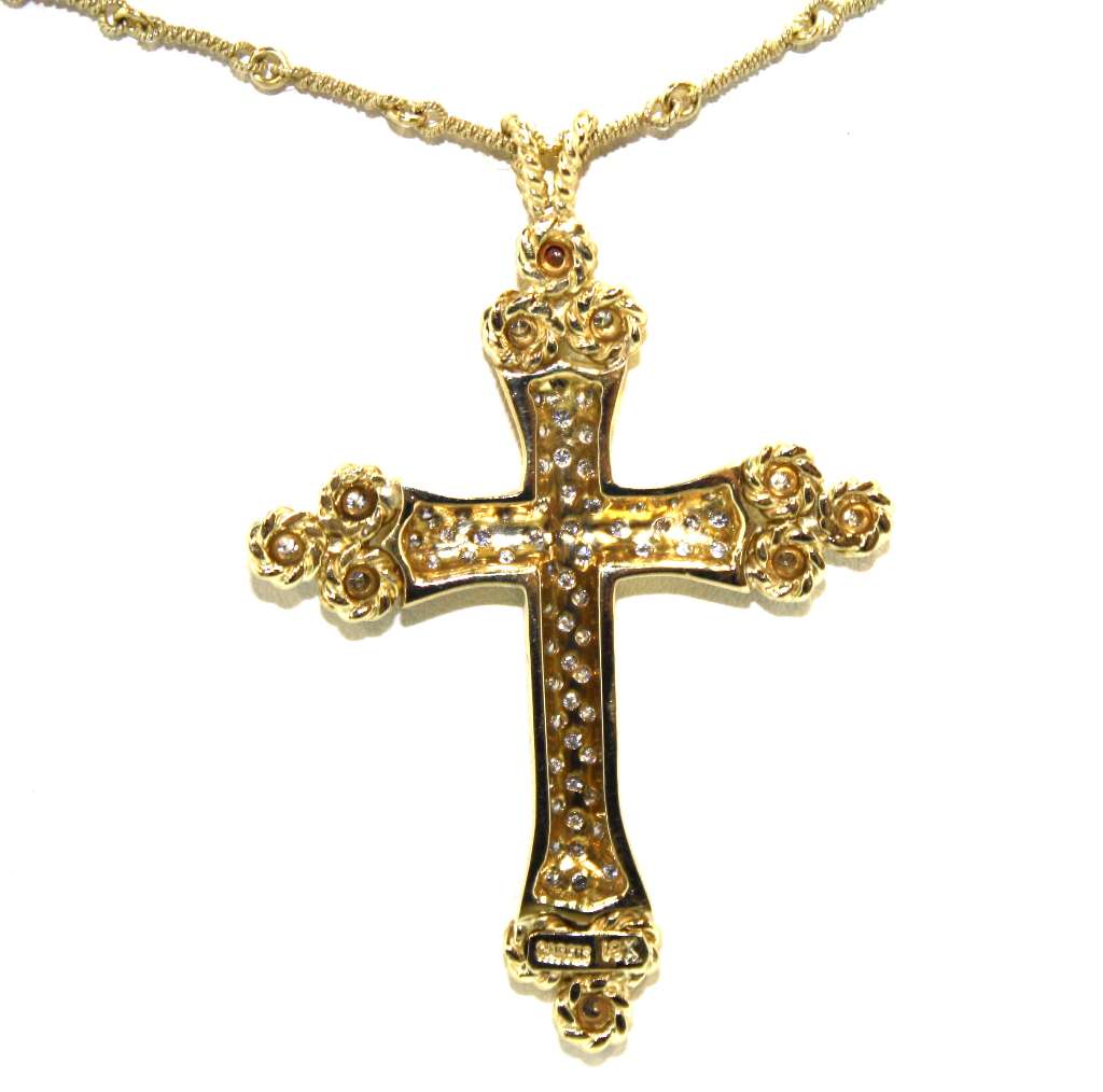Detailed view of sparkling diamonds in 18kt yellow gold cross pendant with reflective surface