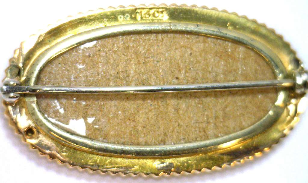 Detailed shot of 15kt yellow gold brooch with white seed pearls, showcasing lustrous pearl quality and vintage craftsmanship