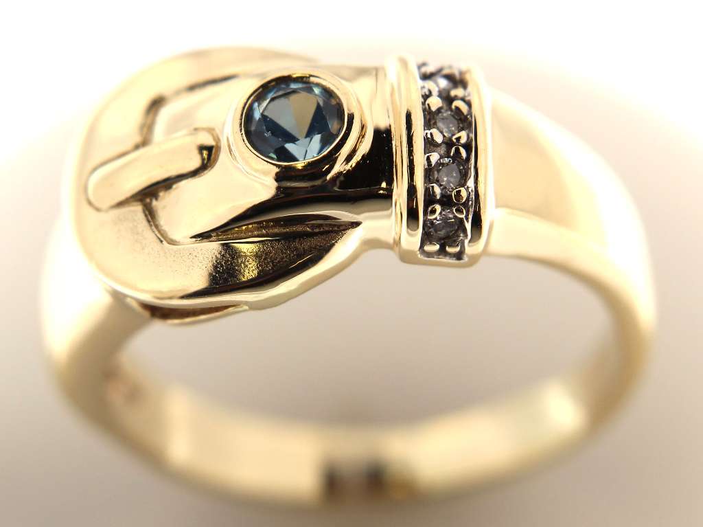 Front view of 14kt yellow gold ring with prominent round blue topaz and sparkling bezel-set diamonds, highlighting ring shape