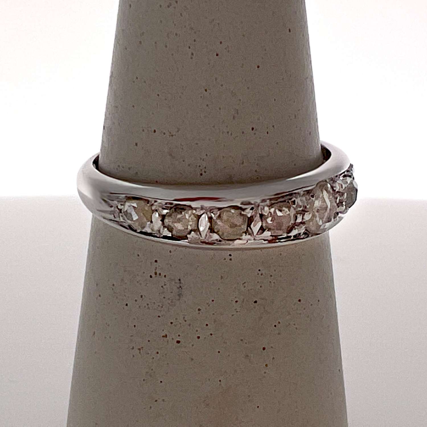 Side angle of antique 18kt white gold diamond band showing detailed bead setting and vintage craftsmanship