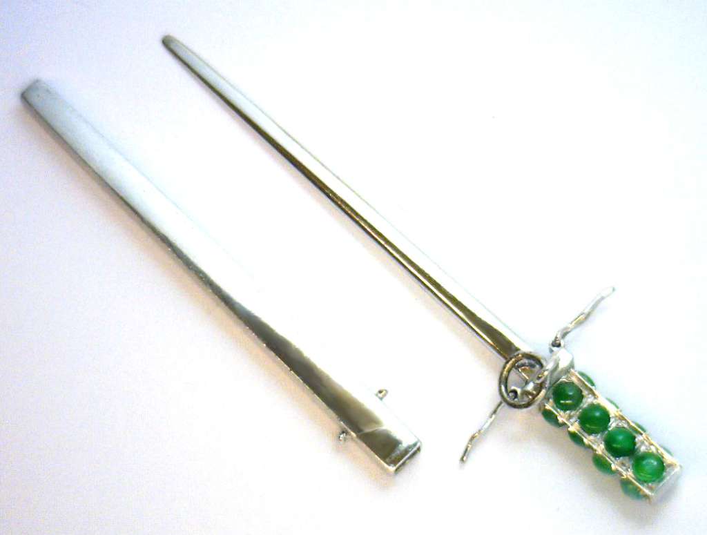Front view of elegant 14kt white gold pendant featuring 16 green jade stones arranged in sword motif, polished and reflective surface
