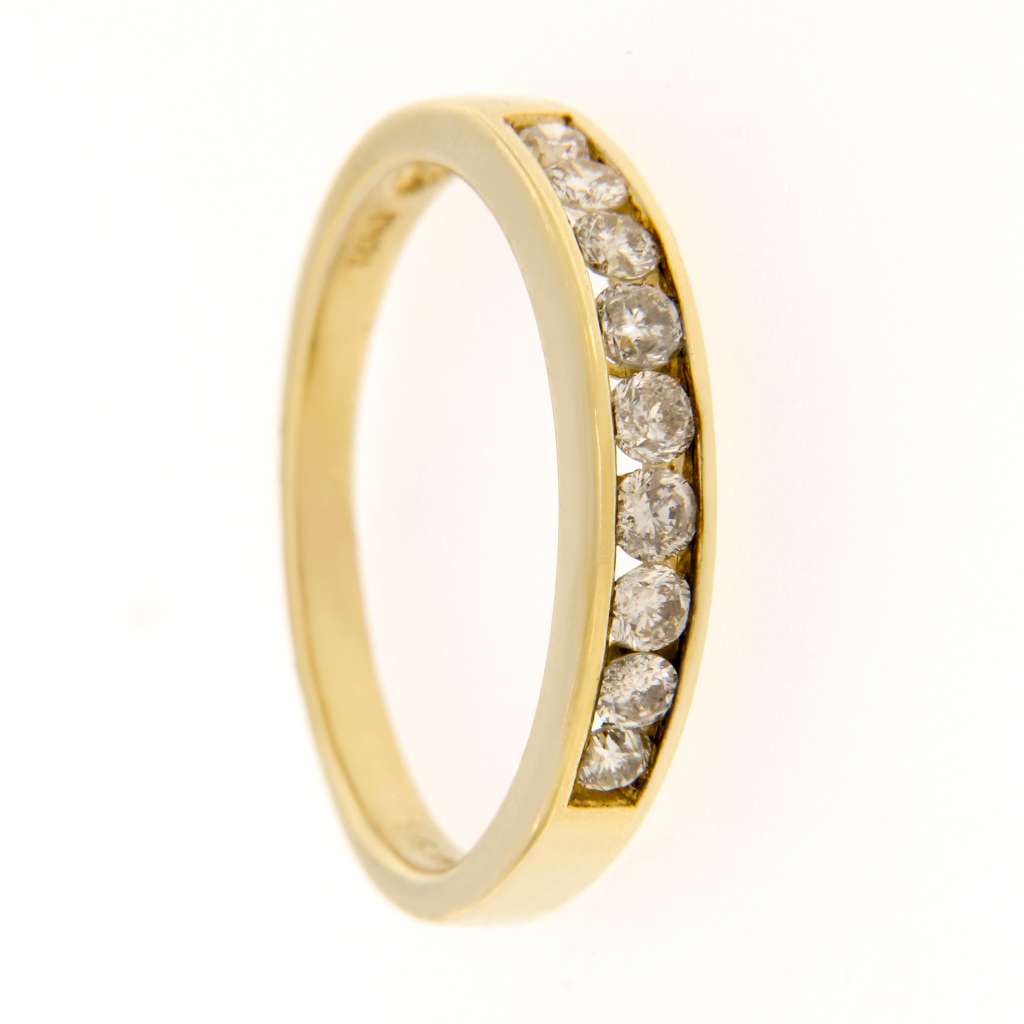 Close-up view of ladies' 14kt yellow gold diamond band with nine round diamonds, emphasizing clarity and color of each stone.