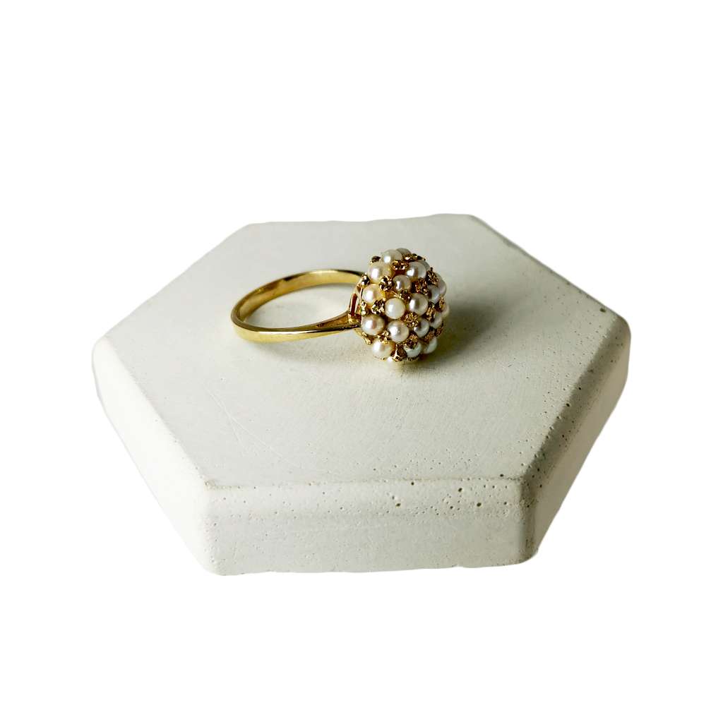 Side angle of 10kt yellow gold pearl ring showing smooth gold band and detailed pearl setting