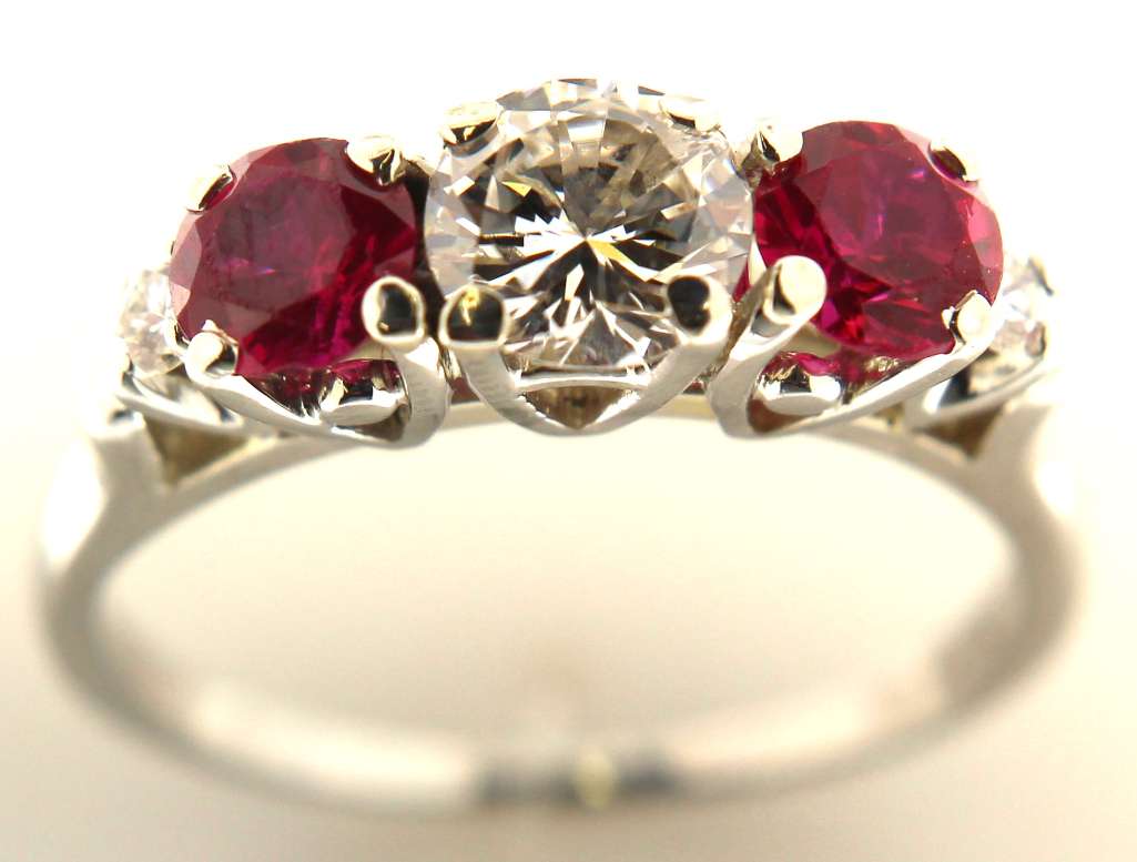 Side angle of 18kt white gold ring highlighting claw diamond setting and round synthetic rubies