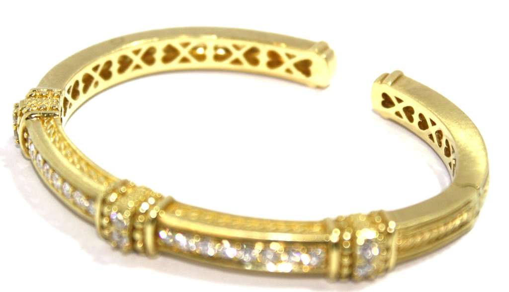 Side angle of 18kt yellow gold diamond bangle highlighting its polished finish and diamond settings