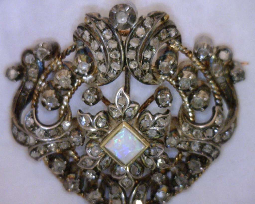 Artisan Victorian brooch featuring pear-shaped dangling opal and lace-like diamond settings