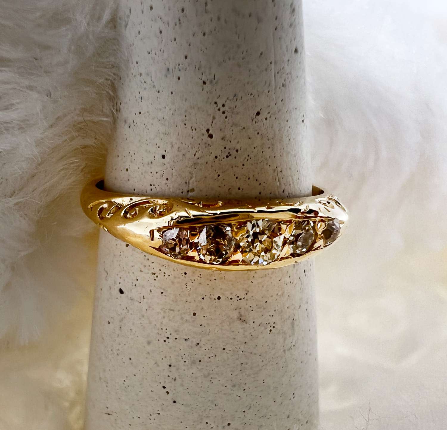 Close-up top view of 18kt yellow gold diamond band featuring 5 old mine cut diamonds totalling 0.23cttw