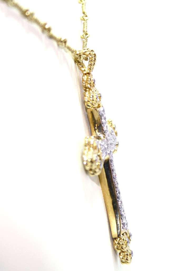 Side profile of 18kt yellow gold diamond cross pendant showing thickness and polished finish