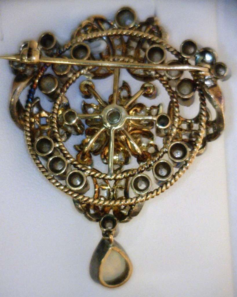 Detailed top-down image of Victorian style opal and diamond brooch with gold and silver craftsmanship