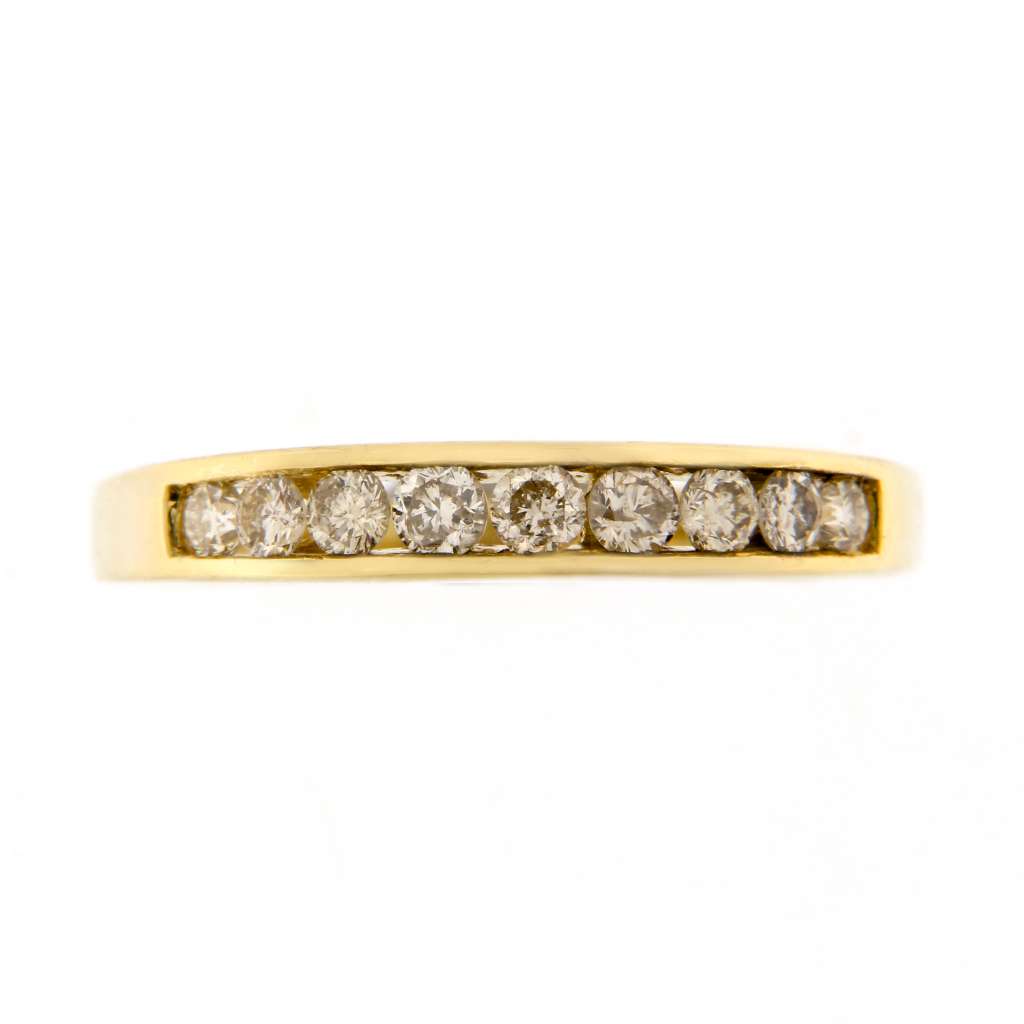 14kt yellow gold diamond band showcasing nine round brilliant cut diamonds in channel setting, angled to highlight sparkling stones on ring size 8.