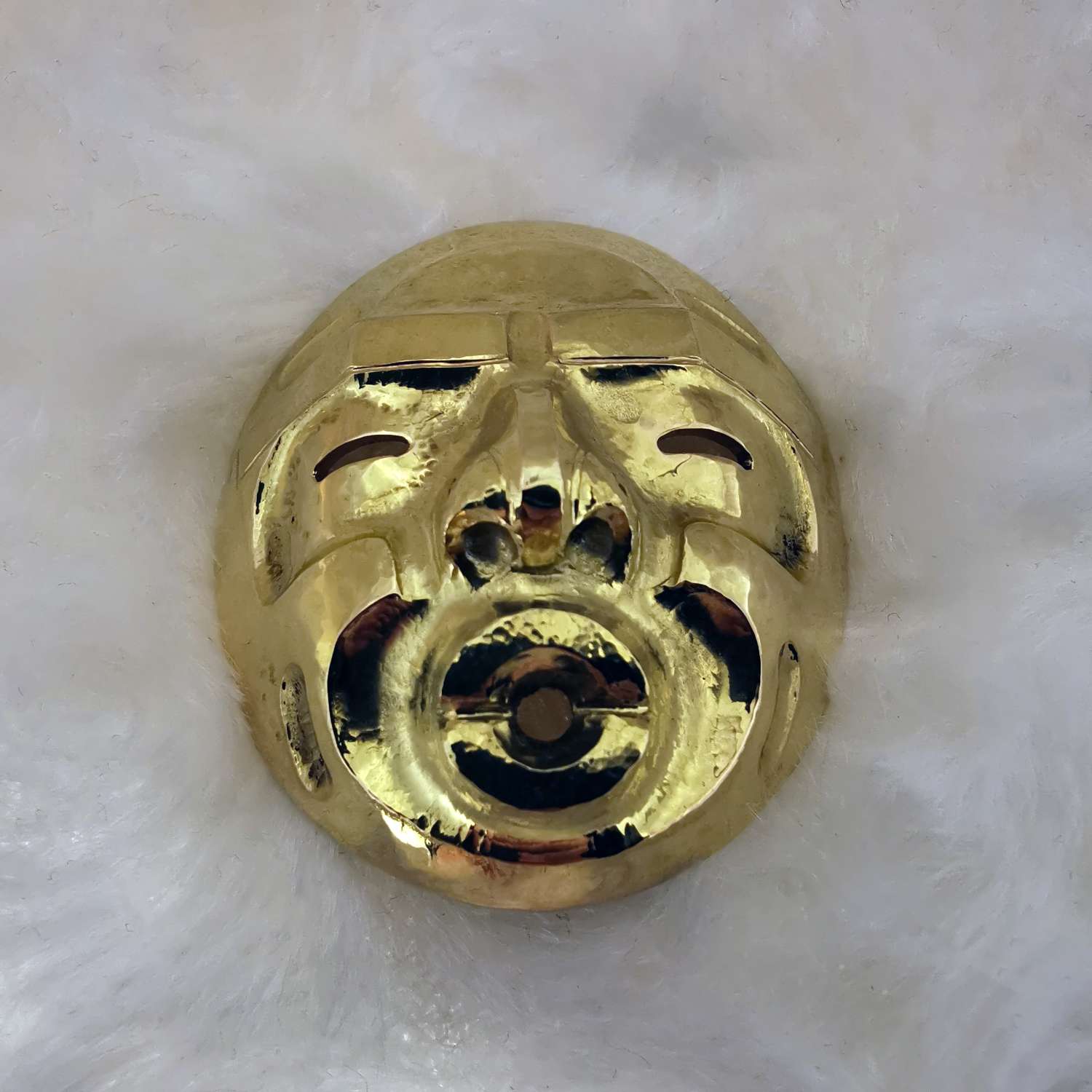 18kt yellow gold Native Indian mask pendant carved in Alert Bay style, front angle view, weighing 17.45 grams