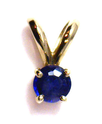 Elegant 14kt white gold pendant with a 3mm round blue sapphire, front angle close-up